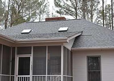 A shingle porch roof with sunlights by the roofers at Housetop Roofing & Home Improvement in Wake Forest, NC.