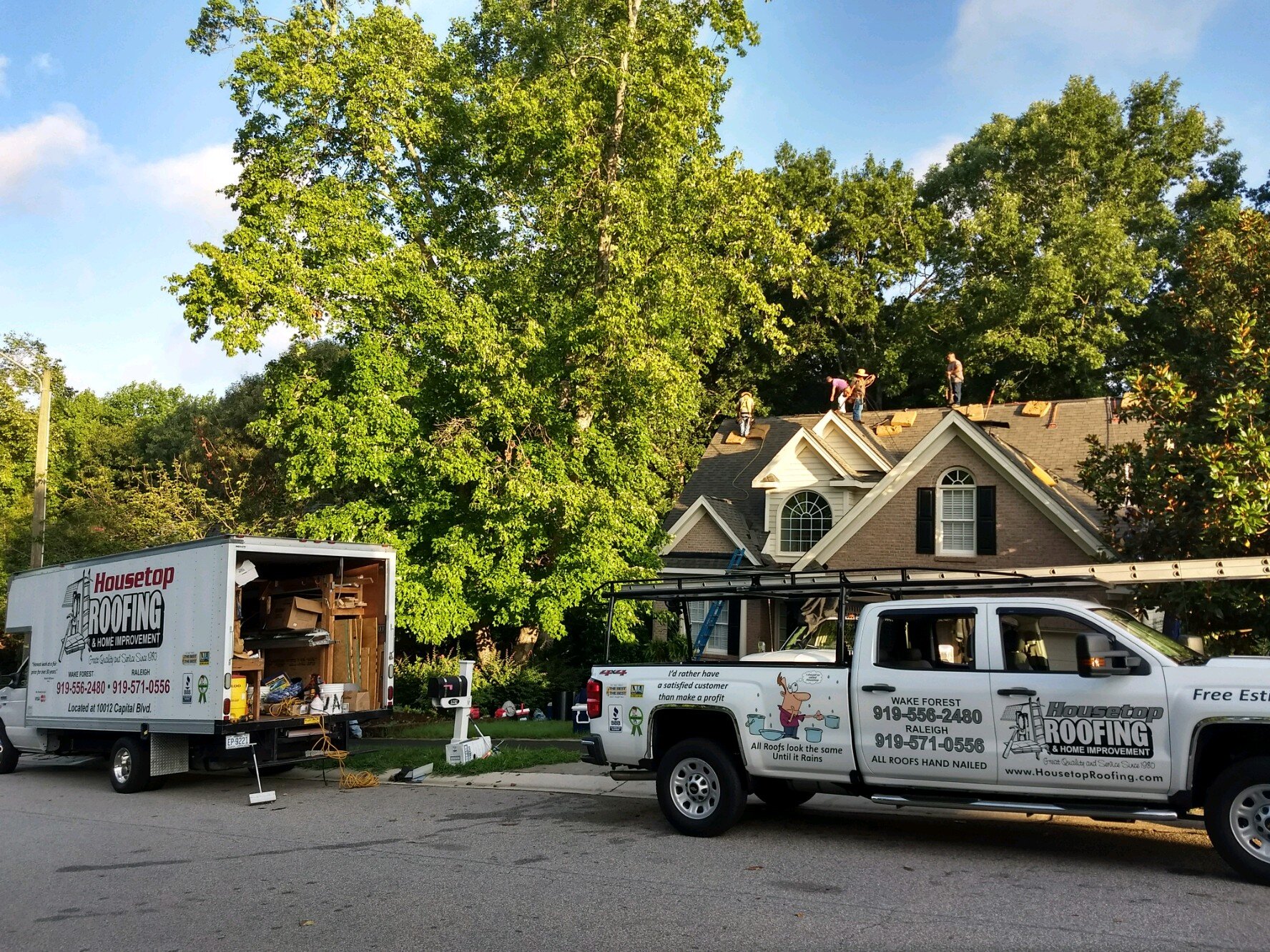 Housetop Roofing and their work trucks roofing another home in Wake Forest, NC.