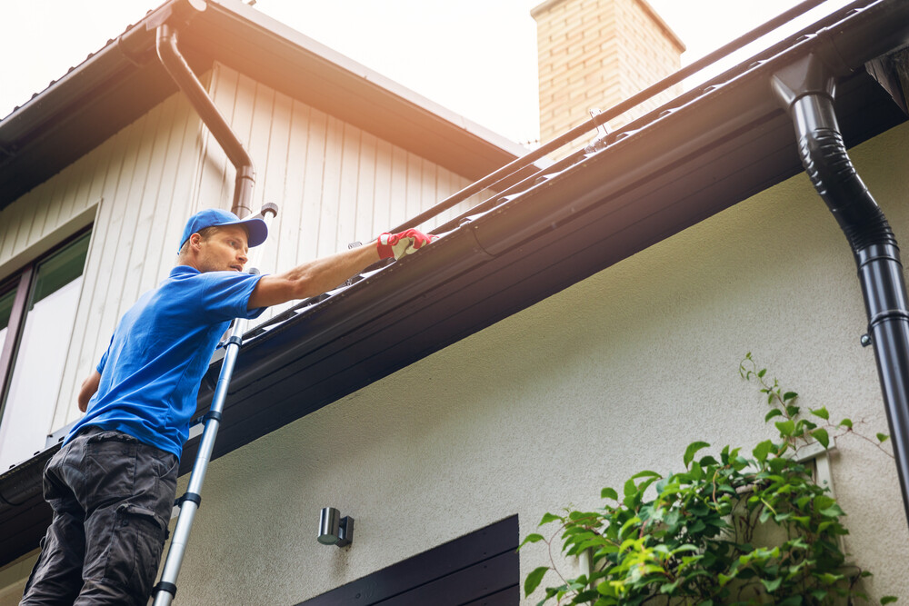 Technician cleaning a gutter