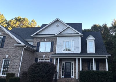 Brick and gray siding two-story home with a new black architectural shingle roof.