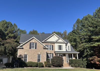 Two-story brick home with a new charcoal gray architectural shingle roof and steep front gables.