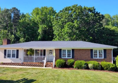 Brick ranch home in Wake Forest, NC with a front porch and new light gray architectural shingles.
