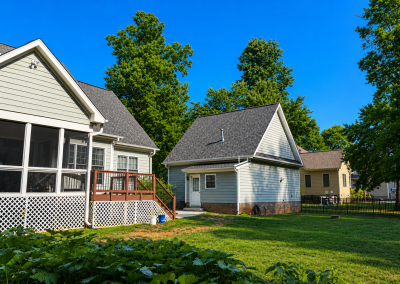 Backyard detached garage and main house both topped with new gray architectural shingles.