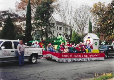 Housetop Roofing & Home Improvements holiday float and company truck in a Christmas parade in 2000.