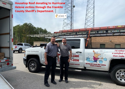 Housetop Roofing team beside a company truck, donating to Hurricane Helene victims through the Franklin County Sheriff's Department.