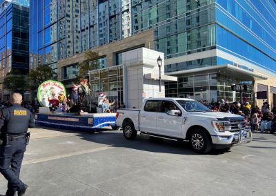 Housetop Roofing holiday float pulled by a white pickup truck through downtown Raleigh during the Christmas parade.