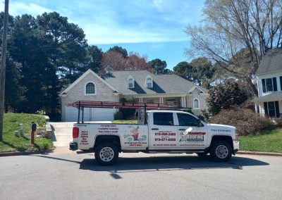 Housetop Roofing work truck with ladder rack parked in front of a home after a roof replacement.