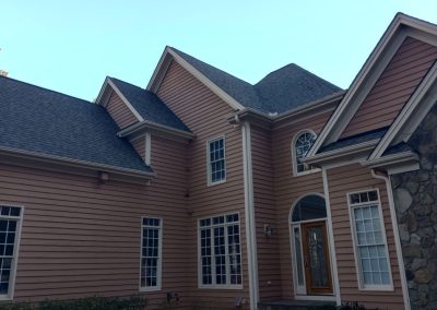 Multi-gable home in Raleigh, NC with stone accents and a new dark architectural shingle roof.