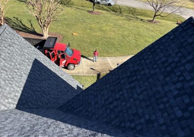 Rooftop view of newly installed gray architectural shingles meeting at a roof valley.