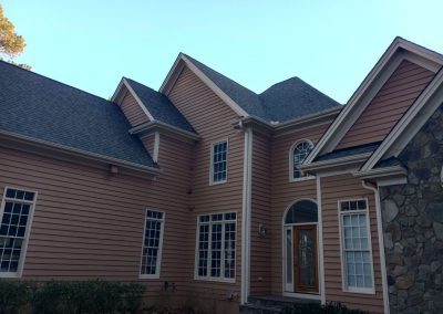 Front of a multi-gable home in Raleigh, NC with new dark shingles over stone and siding.