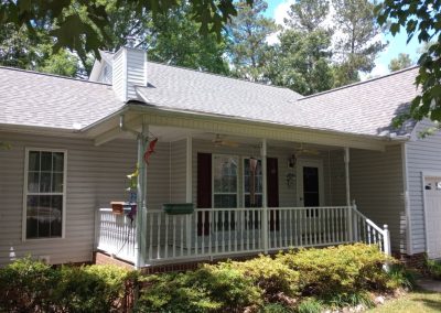 Single-story home with a covered front porch and a new light gray architectural shingle roof.