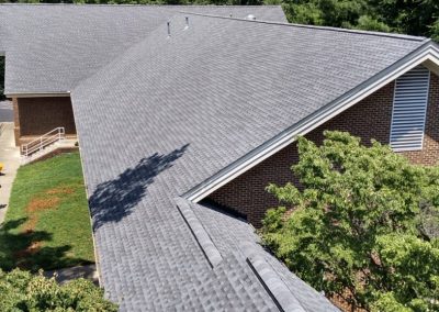 Overhead view of new gray shingles and ridge vent along an intersecting roofline in Raleigh, NC.