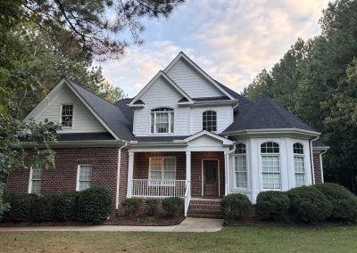 Brick and white siding two-story home with a front porch and a new charcoal shingle roof.