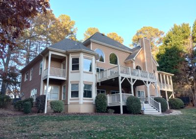 Back of a two-story home with multi-level decks and a new gray architectural shingle roof.